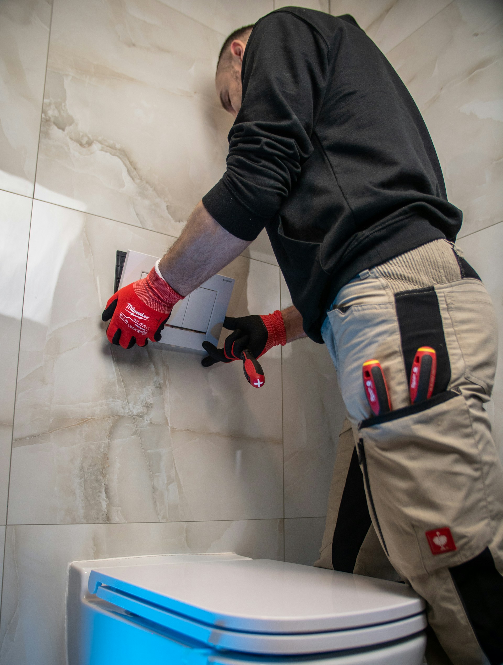 Plumber working on toilet flush panel